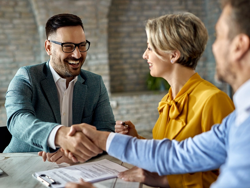 People shaking hands in a meeting.