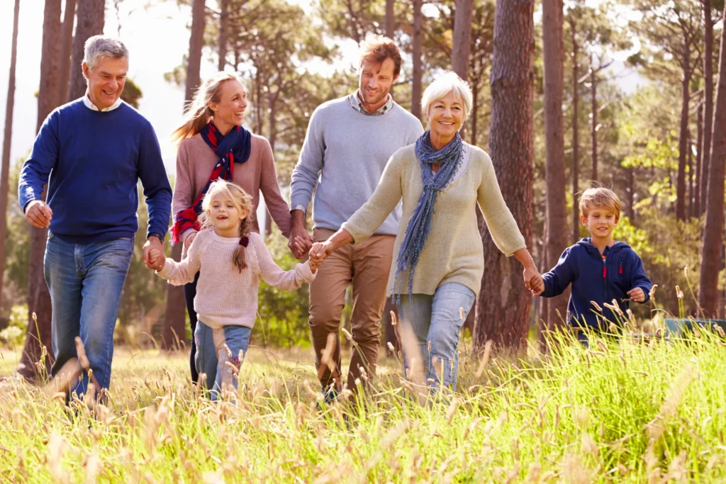 Family walking together in a sunny forest.
