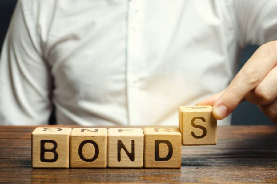 Person placing 'S' block to form the word 'BONDS' with wooden letter blocks.